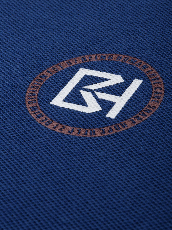 Menjadi T-shirt kolar polo biru manusia dengan perincian bercetak