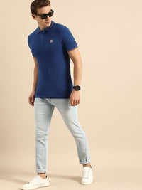 Menjadi T-shirt kolar polo biru manusia dengan perincian bercetak