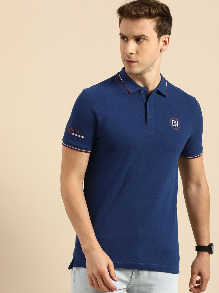 Menjadi T-shirt kolar polo biru manusia dengan perincian bercetak